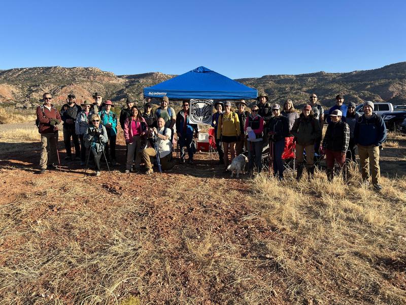 A group of about forty hikers gathered beneath the canyon rim
